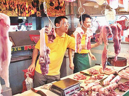 图为:陈生(左一)在卖肉摊点前